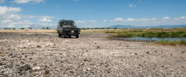 Safari vehicle at Lake Natron in front of Ol Doinyo Lengai