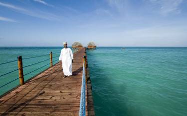 Thumbnail of Waiter walking on a jetty leading to a beach bar