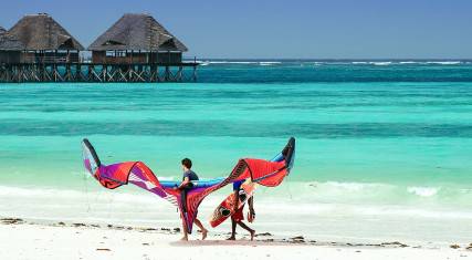 Kitesurfers walking on the beach