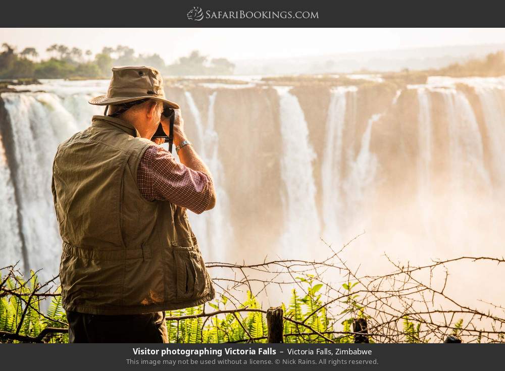 Visitor photographing Victoria Falls in Victoria Falls, Zimbabwe